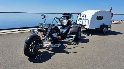 Trike mit weißem KLEOX shelter travel auf einer Uferpromenade am See